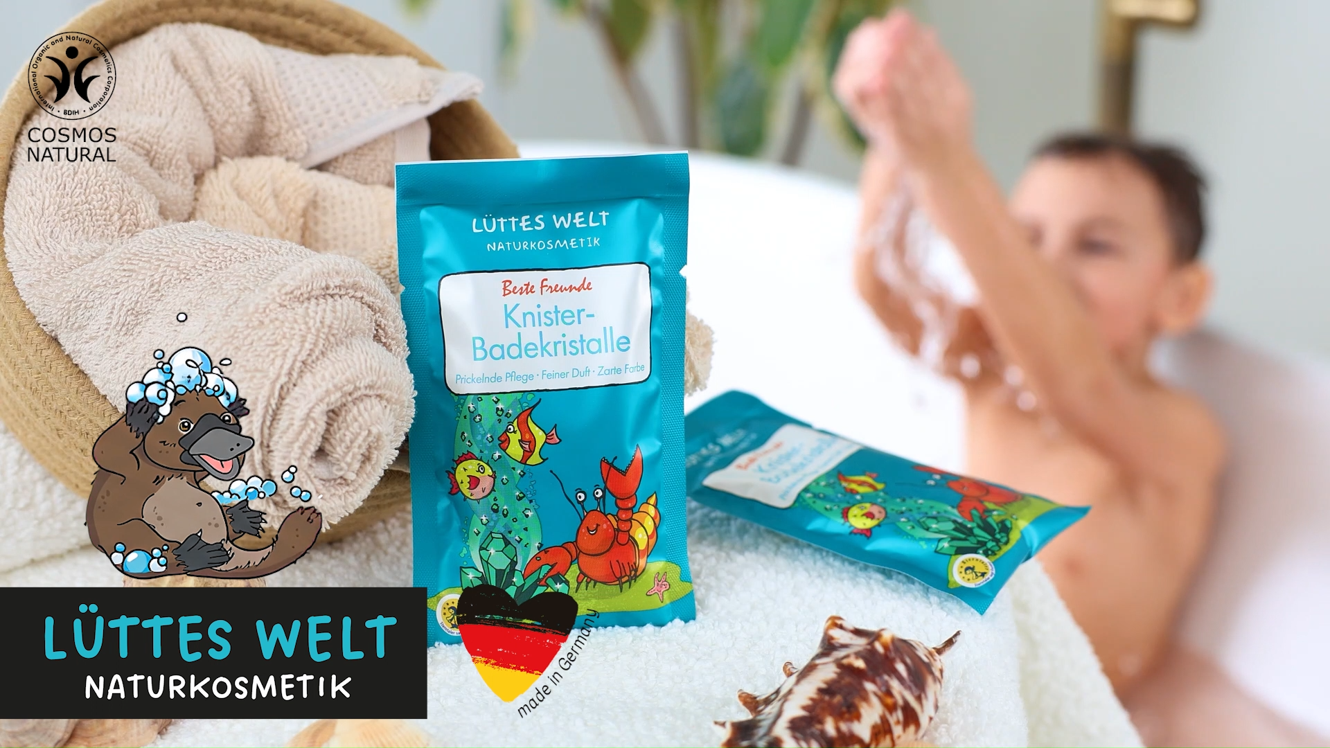 Junge badet in einer Badewanne mit verschiedenen Badeprodukten für Kinder von der Marke Lüttes Welt