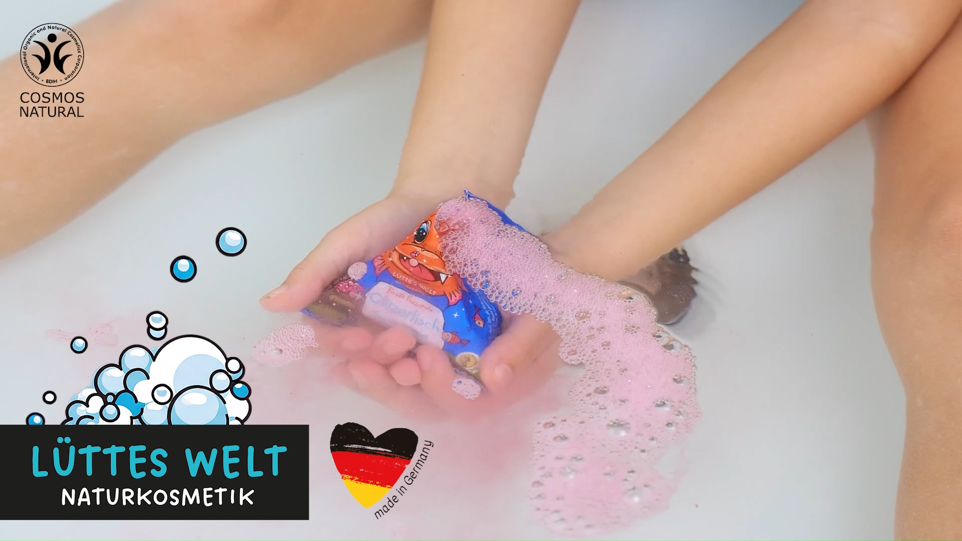 Junge badet in einer Badewanne mit verschiedenen Badeprodukten für Kinder von der Marke Lüttes Welt