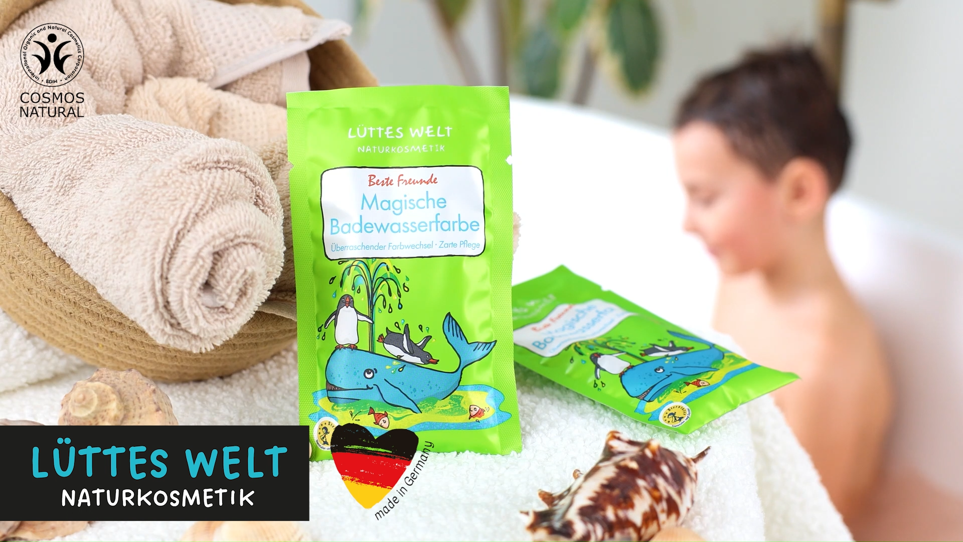 Junge badet in einer Badewanne mit verschiedenen Badeprodukten für Kinder von der Marke Lüttes Welt